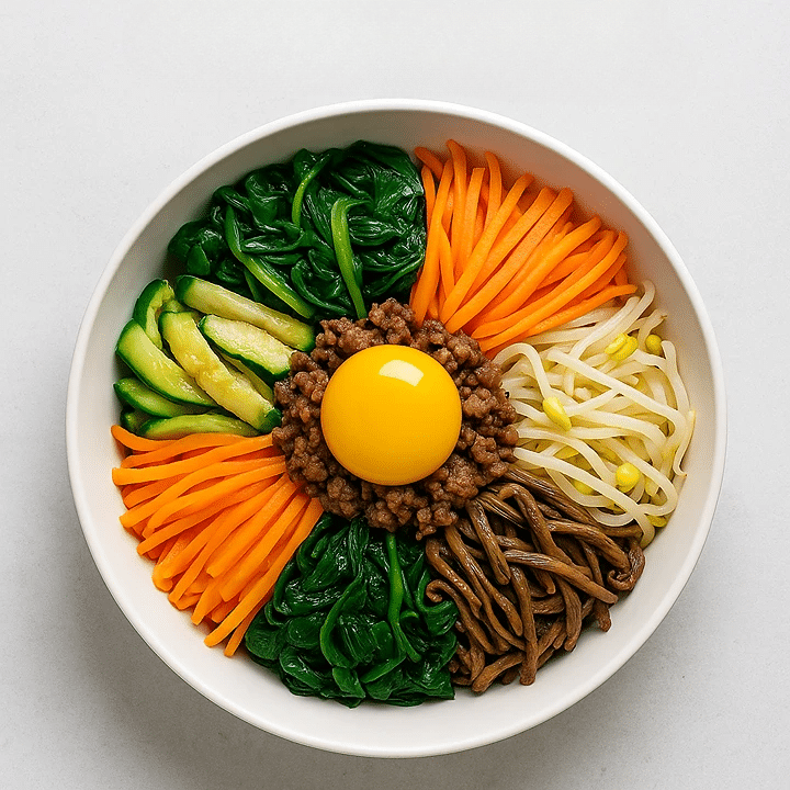 Overhead view of colorful Korean bibimbap in a black bowl